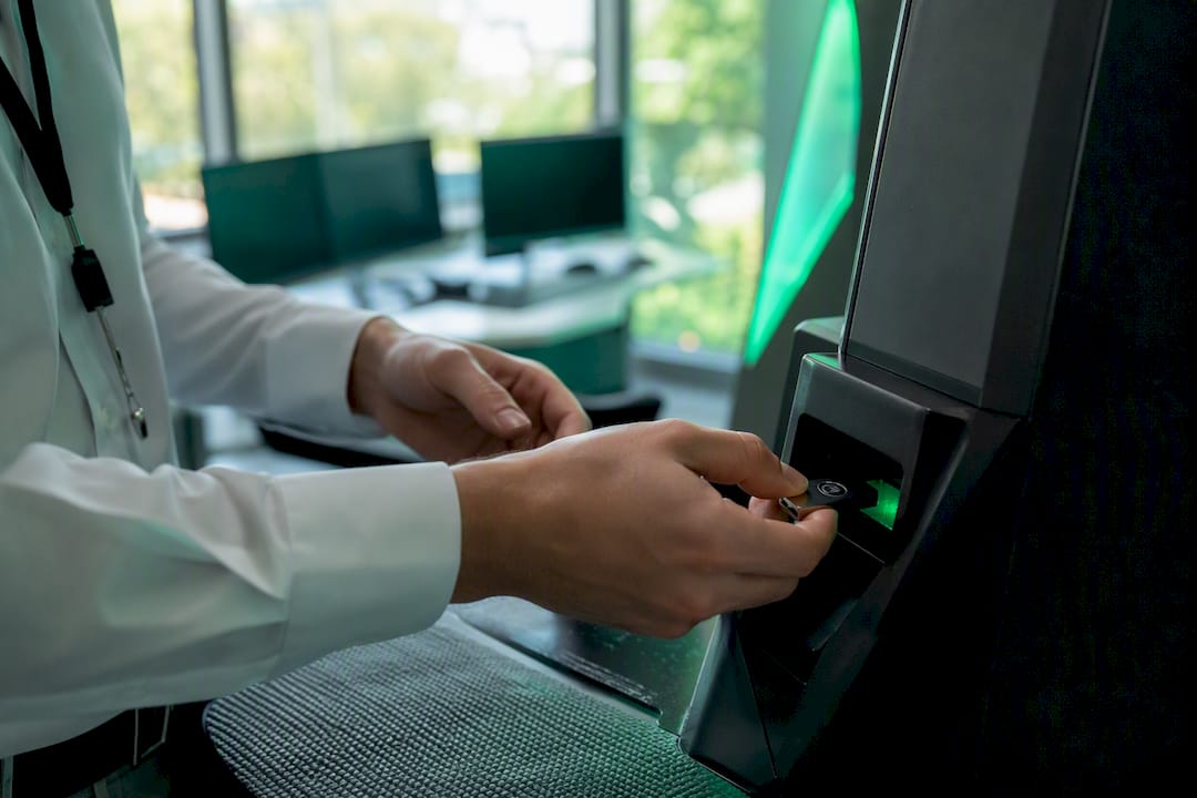 Hands installing cryptographic token into biometric device