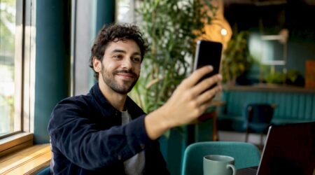 Hand holding phone ready for selfie verification