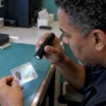Examiner tilts a driver's license under light