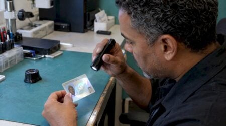 Examiner tilts a driver's license under light