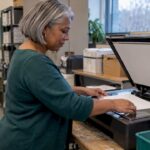 Staff member prepares a document for scanning