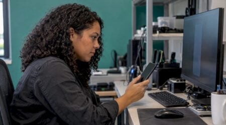 Engineer comparing a handset with an emulator